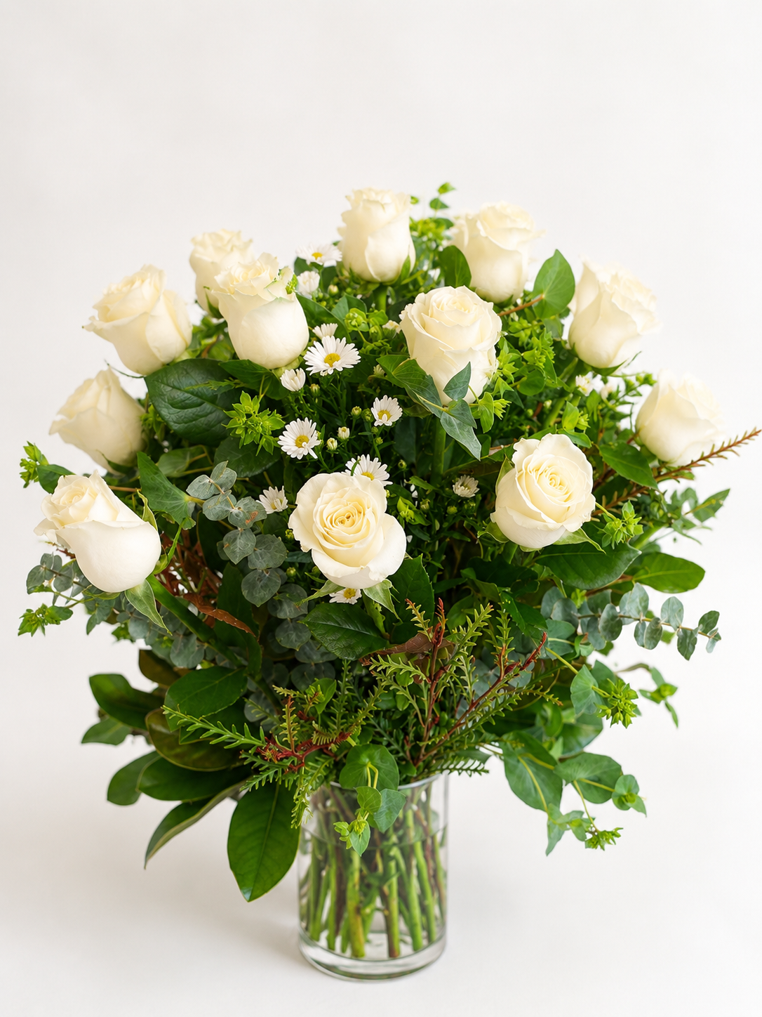 Elegant white rose arrangement with lush greenery and delicate white accent flowers