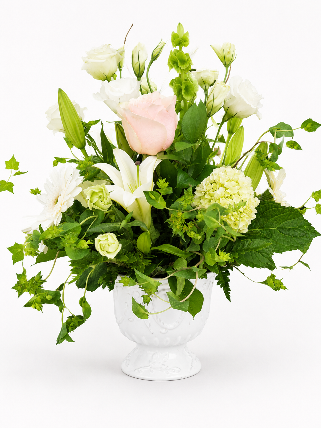 A Quiet Tribute white and green sympathy floral arrangement in an elegant pedestal container