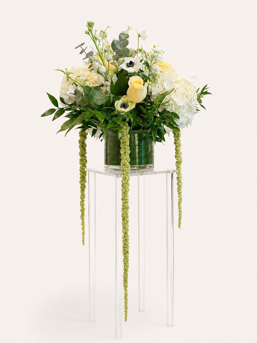 Elegant cascading wedding centerpiece with white flowers, soft yellow roses and lush greenery